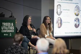 Two people speaking on a panel at conference
